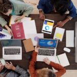 A diverse team collaborating on digital marketing strategies at a desk, using laptops and tablets.